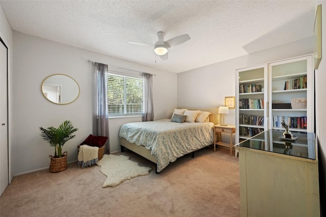 bedroom with light carpet, a textured ceiling, and ceiling fan