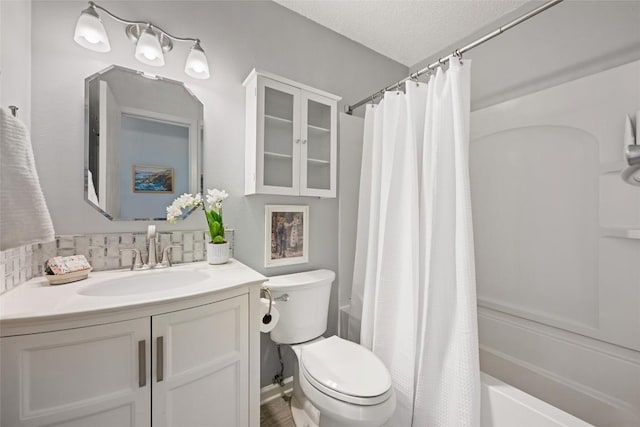 bathroom featuring vanity, toilet, shower / bath combo, and a textured ceiling