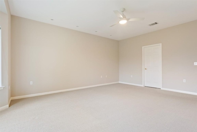 empty room featuring ceiling fan, baseboards, visible vents, and light carpet