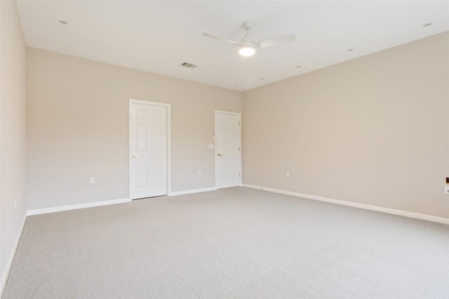 empty room featuring visible vents, a ceiling fan, baseboards, and light carpet