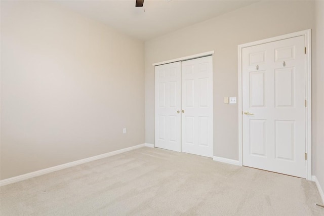 unfurnished bedroom featuring a closet, baseboards, carpet, and ceiling fan