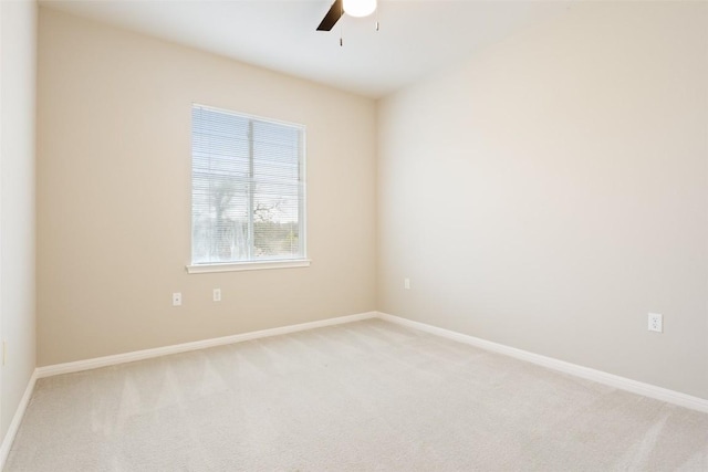 spare room with baseboards, light carpet, and ceiling fan