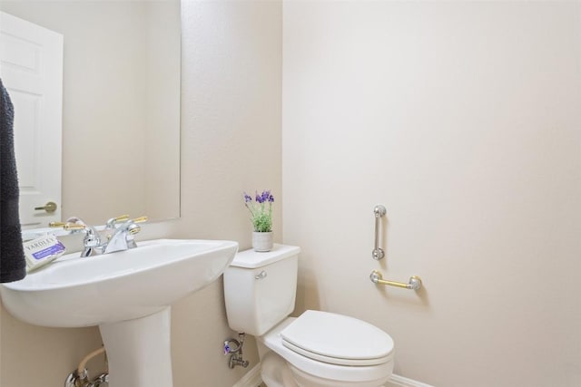 half bathroom with toilet and baseboards