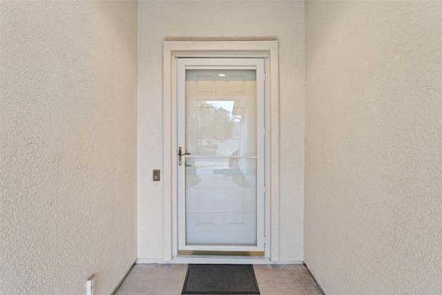 entrance to property featuring stucco siding