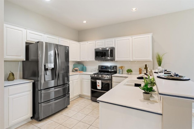 721 Texas Dr, Georgetown, TX 78633 - kitchen featuring appliances with stainless steel finishes, a sink, a peninsula, light tile patterned flooring, and white cabinets