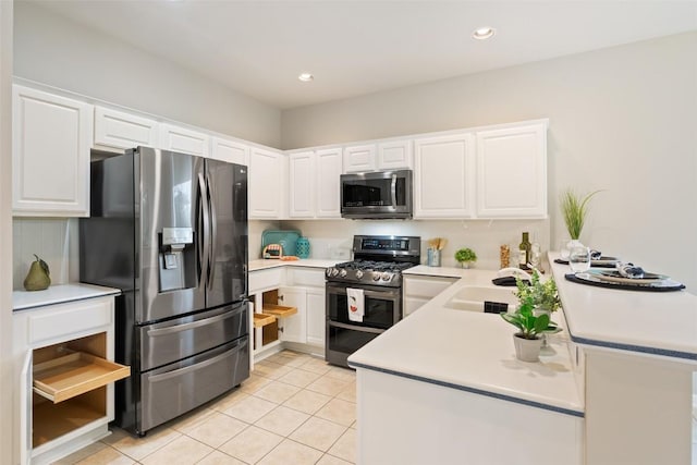 kitchen featuring a sink, stainless steel appliances, a peninsula, and white cabinetry