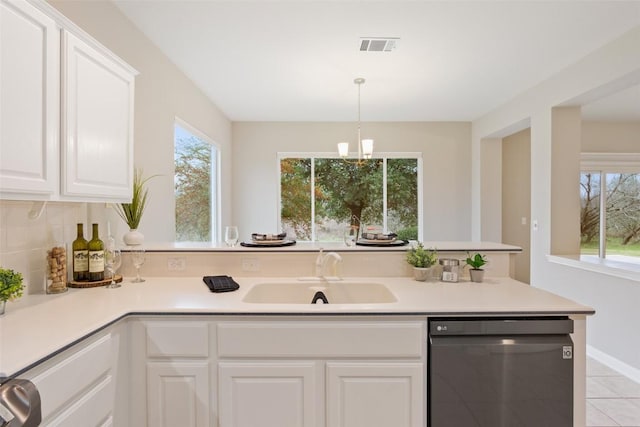 kitchen featuring dishwashing machine, a healthy amount of sunlight, light countertops, and a sink