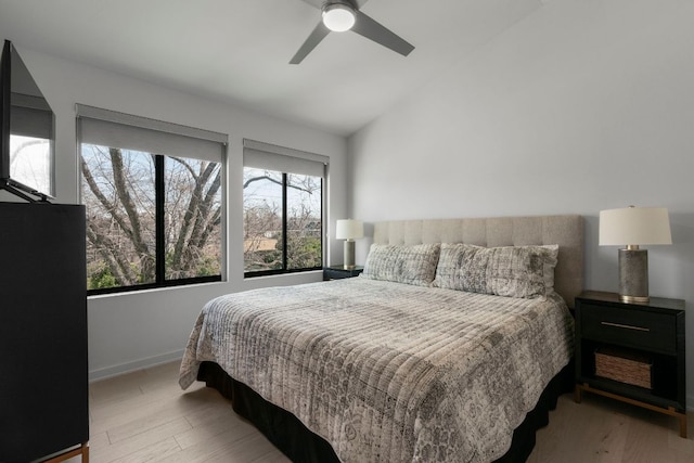 bedroom featuring baseboards, wood finished floors, a ceiling fan, and vaulted ceiling