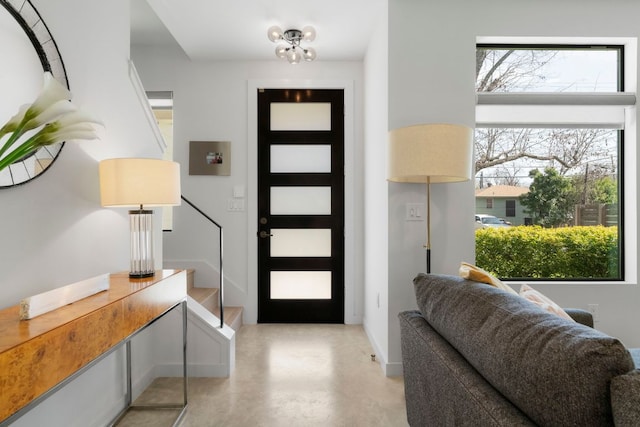 entryway featuring stairs and finished concrete flooring