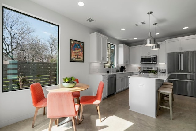 kitchen with stainless steel appliances, tasteful backsplash, visible vents, and light countertops