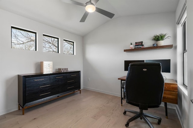 office space featuring a ceiling fan, lofted ceiling, baseboards, and light wood-type flooring