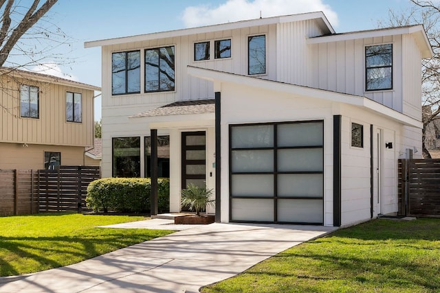 view of front of house featuring a front yard, fence, driveway, a garage, and board and batten siding