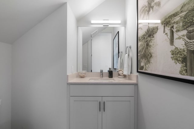 bathroom featuring lofted ceiling and vanity