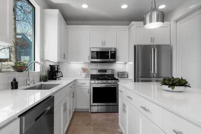 kitchen featuring a sink, decorative backsplash, appliances with stainless steel finishes, and white cabinets