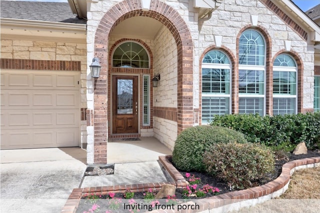 property entrance with brick siding, a shingled roof, a garage, stone siding, and driveway