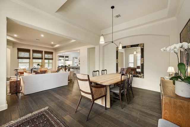 dining area with a tray ceiling, baseboards, visible vents, and dark wood finished floors