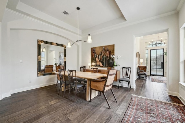 dining space featuring an inviting chandelier, baseboards, a raised ceiling, and dark wood-type flooring