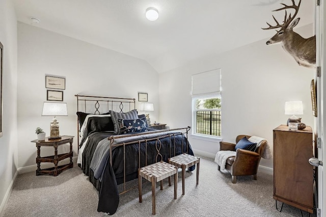 bedroom featuring lofted ceiling, baseboards, and carpet floors