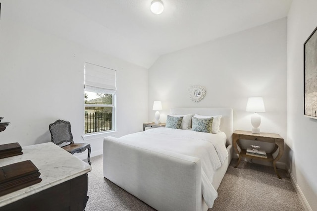 carpeted bedroom with baseboards and vaulted ceiling