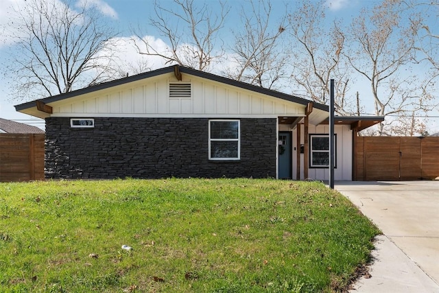 8516 Contour Dr, Austin, TX 78757 - view of front of home featuring fence, concrete driveway, board and batten siding, stone siding, and a front yard