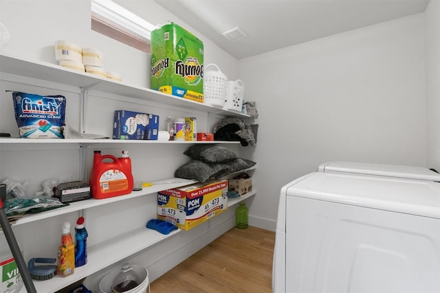 laundry room featuring laundry area, wood finished floors, visible vents, and independent washer and dryer