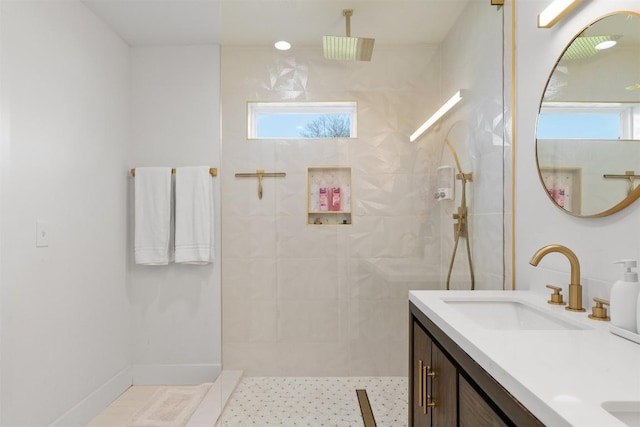 bathroom featuring double vanity, a healthy amount of sunlight, a walk in shower, and a sink