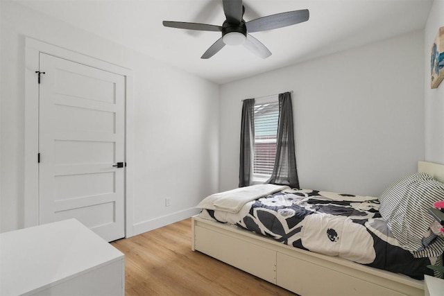 bedroom featuring light wood finished floors, ceiling fan, and baseboards