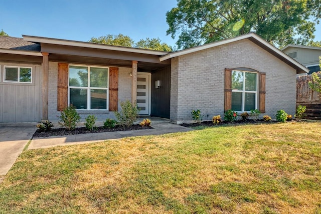 view of front of house featuring a front lawn and brick siding