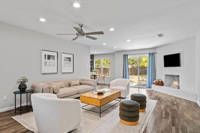 living area with visible vents, wood finished floors, recessed lighting, a fireplace, and baseboards