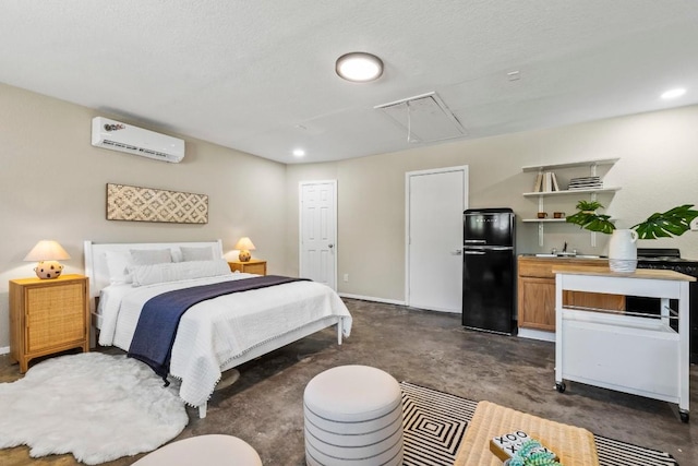 bedroom with an AC wall unit, a sink, freestanding refrigerator, concrete floors, and attic access