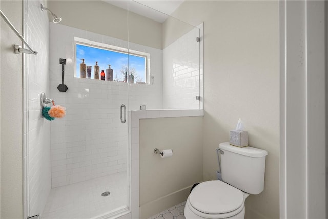 bathroom featuring toilet and a stall shower