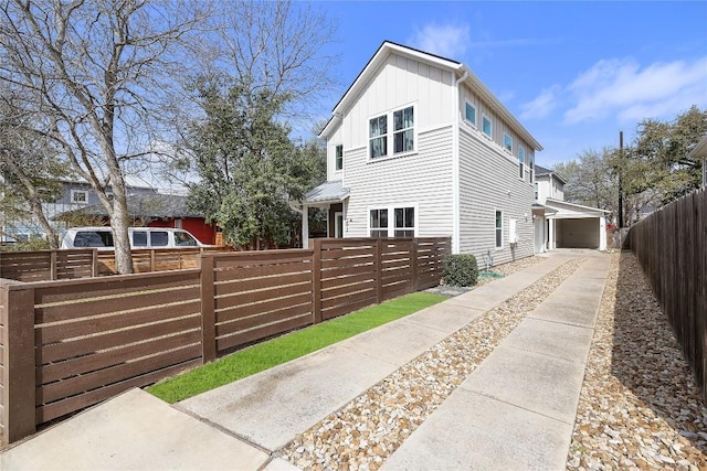 view of side of property featuring a fenced front yard and board and batten siding