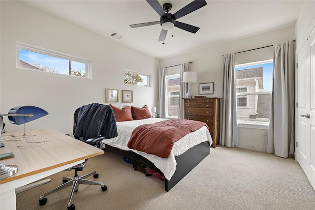 bedroom featuring visible vents, multiple windows, and light colored carpet