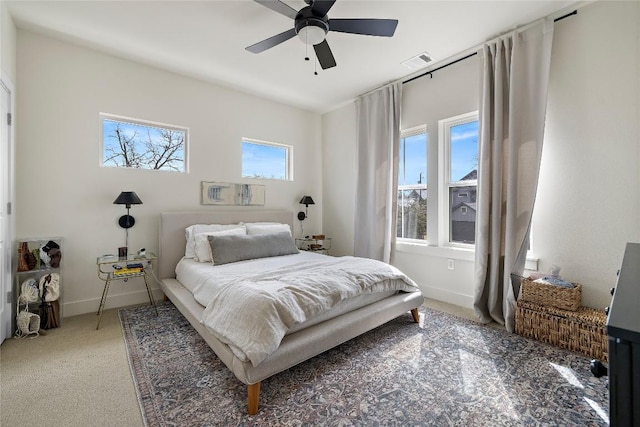 bedroom featuring visible vents, light carpet, baseboards, and a ceiling fan