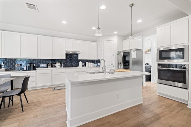 kitchen featuring visible vents, backsplash, appliances with stainless steel finishes, and light wood finished floors