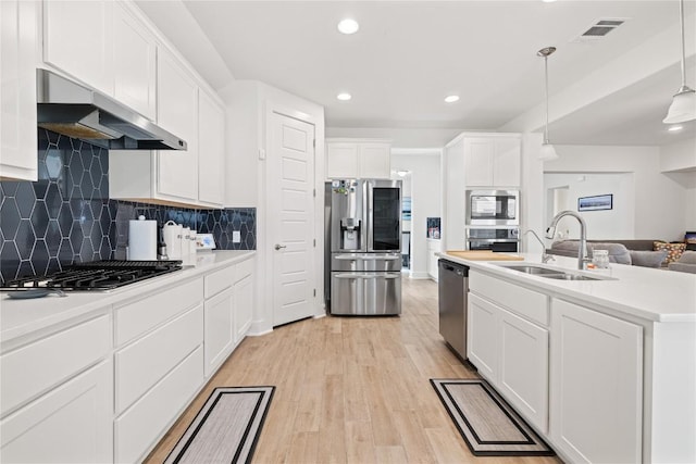 kitchen with visible vents, light wood-style flooring, a sink, stainless steel appliances, and under cabinet range hood