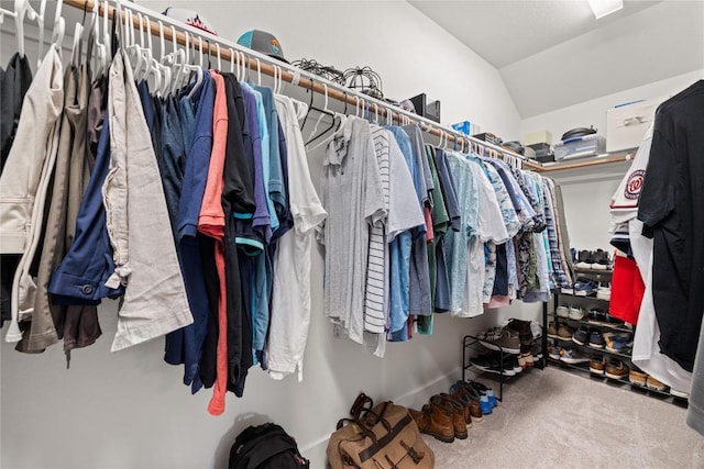 spacious closet with lofted ceiling and carpet flooring