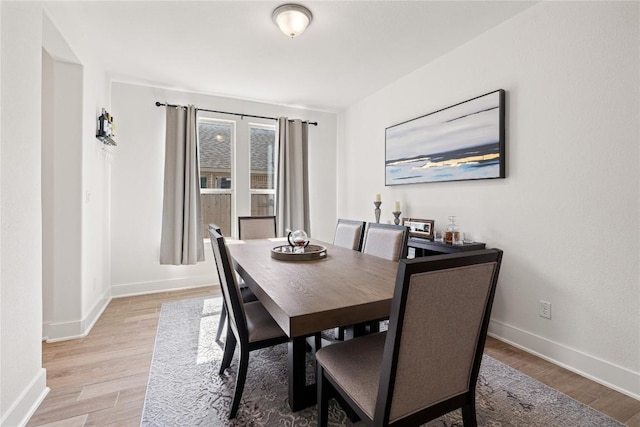 dining room featuring baseboards and light wood-style flooring