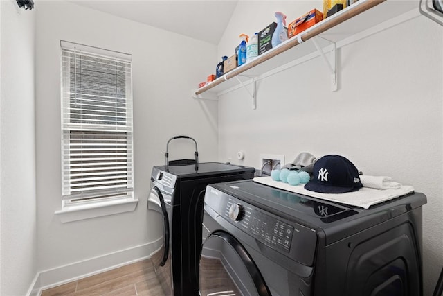 laundry area with washing machine and clothes dryer, laundry area, light wood-style flooring, and baseboards