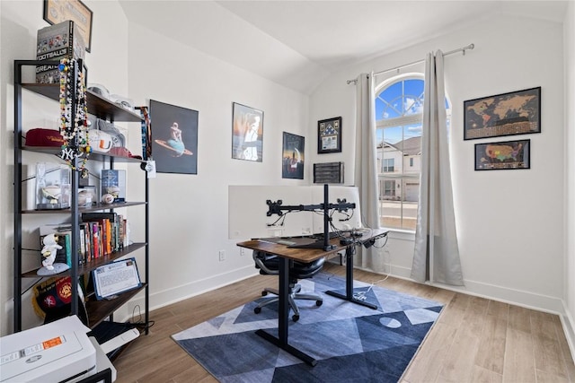 home office featuring baseboards, lofted ceiling, and wood finished floors