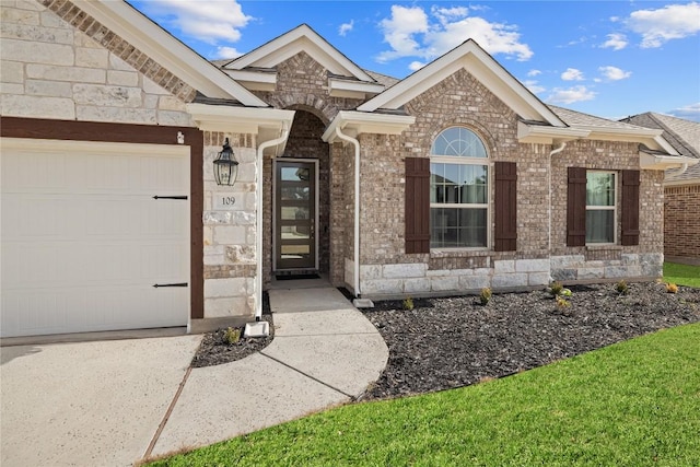 view of front of property with a garage, stone siding, and brick siding