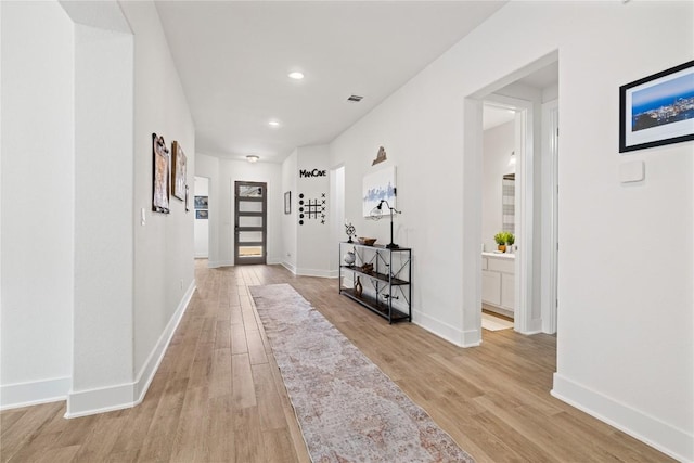 hall with recessed lighting, visible vents, baseboards, and light wood-style flooring