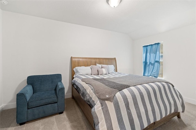 carpeted bedroom featuring baseboards and lofted ceiling