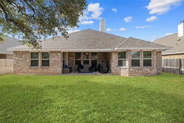 rear view of house with a yard, roof with shingles, and a fenced backyard