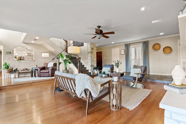 living room featuring wood finished floors, recessed lighting, crown molding, ceiling fan, and stairs