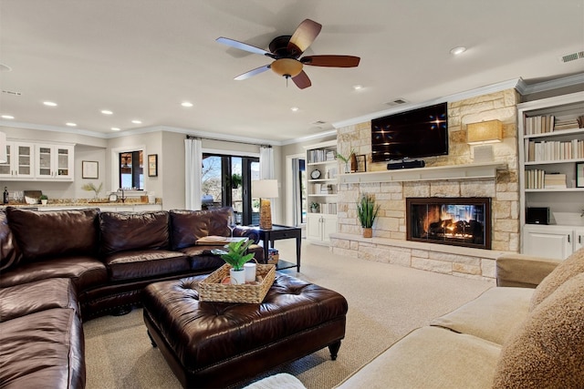 living area featuring recessed lighting, a stone fireplace, carpet flooring, and crown molding