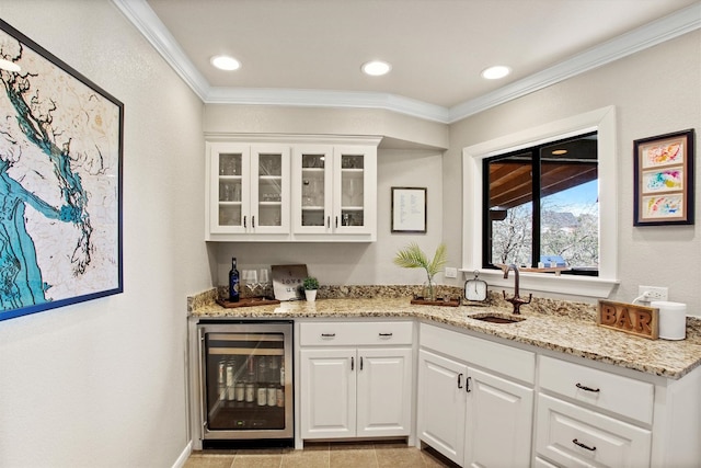 bar featuring light tile patterned floors, wet bar, ornamental molding, a sink, and wine cooler