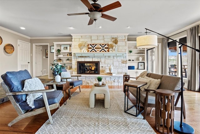 living area featuring a stone fireplace, light wood-style flooring, and crown molding