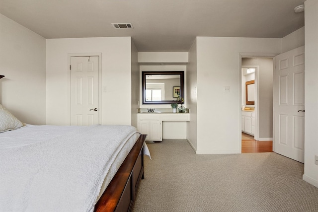 carpeted bedroom with visible vents and baseboards