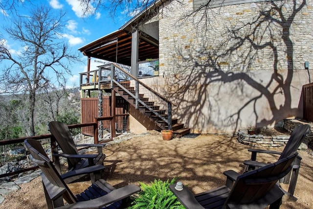 view of patio featuring stairway and fence